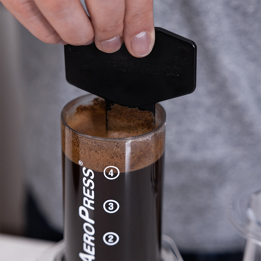 Gefüllte Aeropress Clear Coffee Press mit Rührstab.